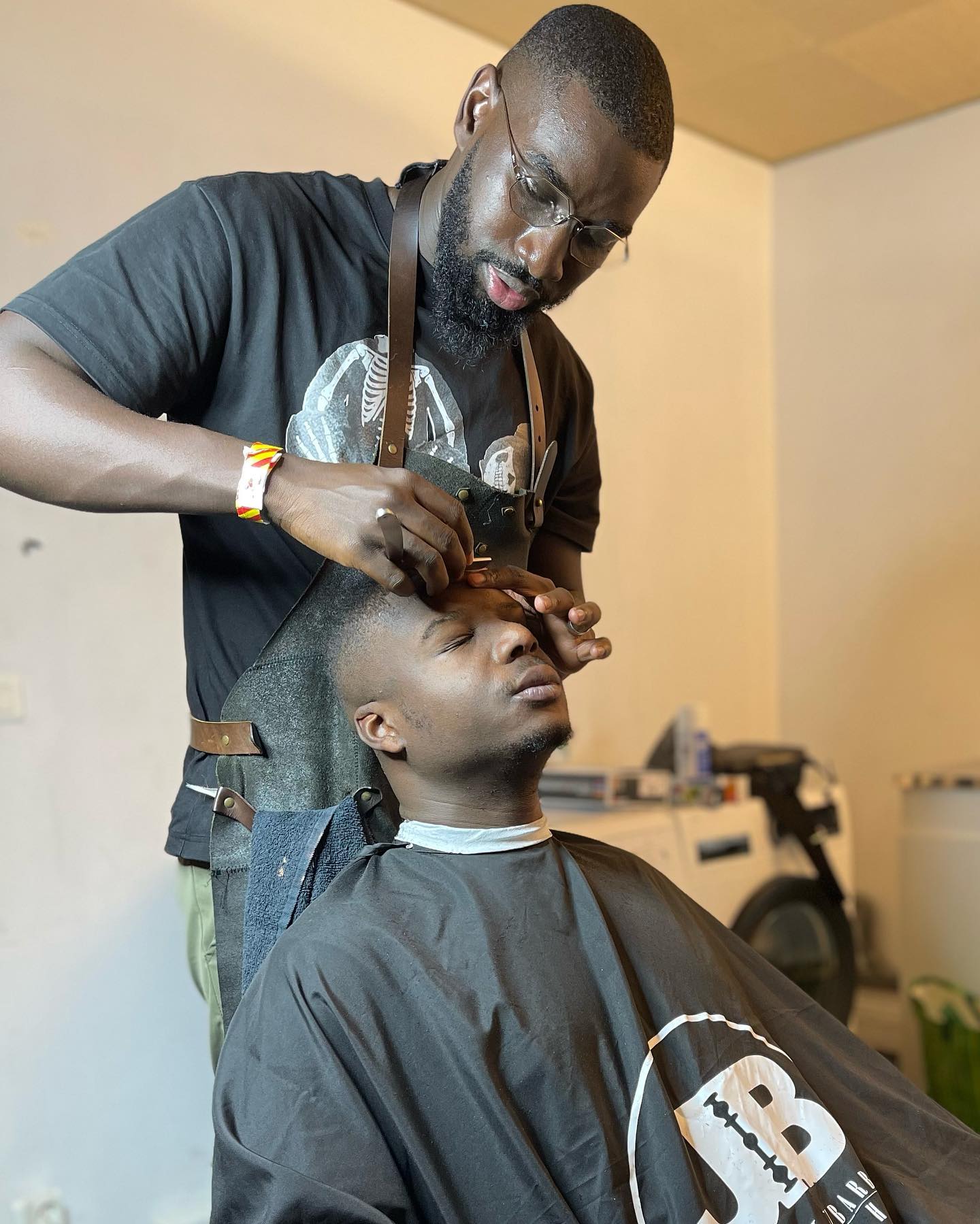 Barbier ajustant les contours au rasoir